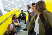 Молодші випускники висять, розмовляють по сходах — стокове фото