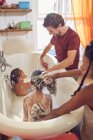 Genitori dando figlie bagno di bolla — Foto stock