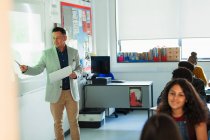 Professor do ensino médio do sexo masculino lição de liderança na tela de projeção em sala de aula — Fotografia de Stock