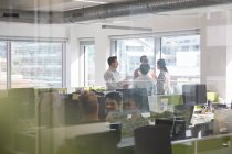 Empresários falando em escritório em plano aberto — Fotografia de Stock