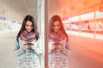 Молода жінка використовує смартфон на залізничній станції — стокове фото