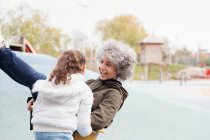 Playful grandmother and granddaughter playing at playground — Stock Photo