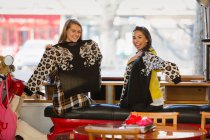 Ritratto felici giovani donne amiche con maglioni corrispondenti in caffè — Foto stock