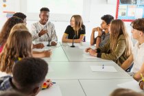 Des lycéens discutent à table en classe de débat — Photo de stock