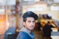 Portrait confident young man in cafe window — Stock Photo