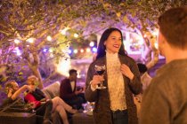 Amici che parlano e bevono vino alla festa in giardino — Foto stock
