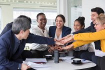 Business people joining hands in meeting — Stock Photo