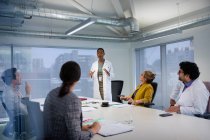 Female doctor leading conference room meeting — Stock Photo