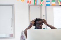 Зріла чоловіча спільнота студента коледжу налаштування навушників на комп'ютері в класі — стокове фото
