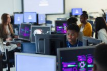 Фокусований молодший школяр, який використовує комп'ютер у темній комп'ютерній лабораторії — стокове фото