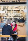 Молоді дорослі друзі розмовляють у тротуарному кафе — стокове фото