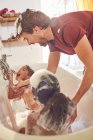 Padre giocoso dando figlie bagno di bolla — Foto stock