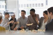 Happy business people enjoying sushi lunch — Stock Photo
