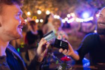 Homem com cartão de crédito pagando bartender na festa — Fotografia de Stock
