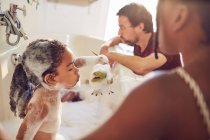 Батьки, які дарують донькам бульбашкову ванну — стокове фото