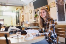Портрет впевнена молода студентка коледжу, яка навчається за столом кафе — стокове фото