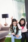 Verspielte Schwestern machen Selfie mit Smartphone im Wohnzimmer — Stockfoto