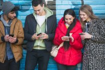 Young adults using smart phones — Stock Photo