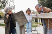 Großeltern und Enkelin spielen auf Spielplatz — Stockfoto