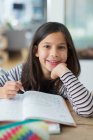 Портрет уверенный, улыбающаяся девушка делает домашнее задание — стоковое фото