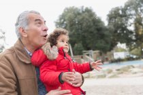 Großvater und Kleinkind-Enkel spielen mit Blasen im Park — Stockfoto