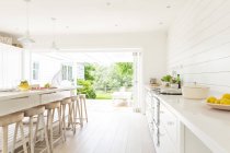 Maison blanche simple vitrine cuisine intérieure ouverte sur patio — Photo de stock