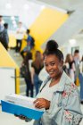 Retrato confiante júnior estudante do ensino médio estudando no corredor — Fotografia de Stock