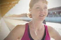 Close up confident young female runner with headphones — Stock Photo