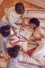 View from above young family coloring on bed — Stock Photo