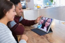 Пара видеоконференций с дочерьми на цифровой планшет на кухне — стоковое фото