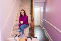 Portrait femme confiante redécorer, en regardant swatch peinture sur les escaliers — Photo de stock