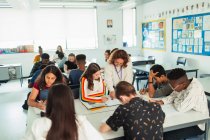Insegnante di scuola superiore aiutare gli studenti a studiare in classe — Foto stock
