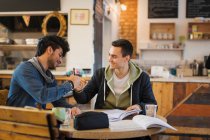 Junge männliche College-Studenten studieren, Faustschlag im Café — Stockfoto