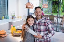 Retrato feliz pai e filha abraçando na cozinha — Fotografia de Stock