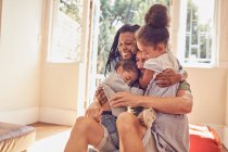 Glückliche, liebevolle junge Familie beim Umarmen — Stockfoto