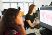 Focalisé junior lycéenne étudiant en utilisant l'ordinateur dans le laboratoire informatique — Photo de stock