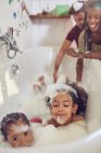 Батьки, які дарують донькам бульбашкову ванну — стокове фото