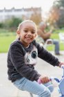 Ritratto sorridente ragazza in bicicletta al parco giochi — Foto stock