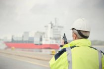 Hafenmanager mit Walkie-Talkie beobachtet Containerschiff am Handelsdock — Stockfoto