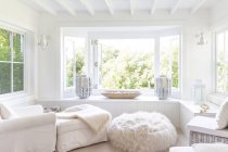 Casa bianca vetrina salotto con finestre aperte sul giardino — Foto stock