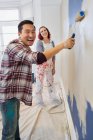 Retrato parede de pintura casal feliz — Fotografia de Stock