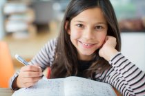 Портрет усміхнений, впевнена дівчина робить домашнє завдання — стокове фото