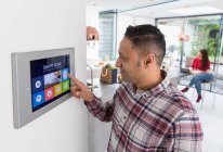 Mann stellt Touchscreen-Smart-Home-Alarm ein — Stockfoto