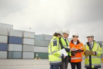 Trabajadores portuarios y gerente hablando en el astillero - foto de stock