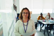 Porträt selbstbewusste Gymnasiallehrerin auf Projektionsfläche im Klassenzimmer — Stockfoto