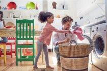 Father and daughter doing laundry in kitchen — Stock Photo