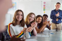 Felices estudiantes de secundaria aplaudiendo en clase de debate - foto de stock
