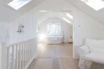 Tranquil blanco a-frame casa escaparate baño con bañera de remojo - foto de stock