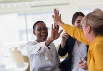 Businesswomen high-fiving in office — Stock Photo