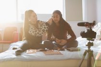 Девушки-подростки vlogging, демонстрируя макияж приложения в солнечной спальне — стоковое фото